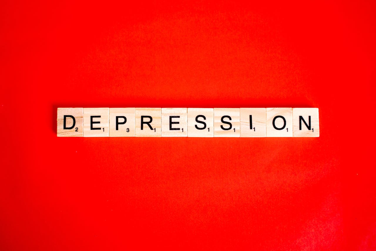 services-01 Word depression spelled with letter tiles on vibrant red background, highlighting mental health theme.
